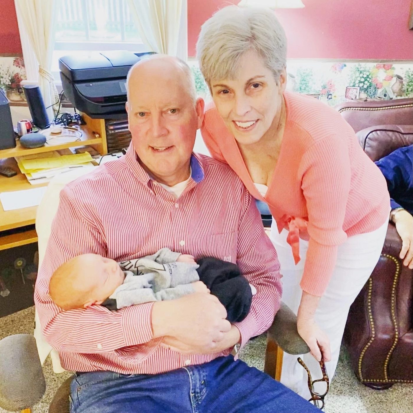 Kady's parents holding their grandson at home