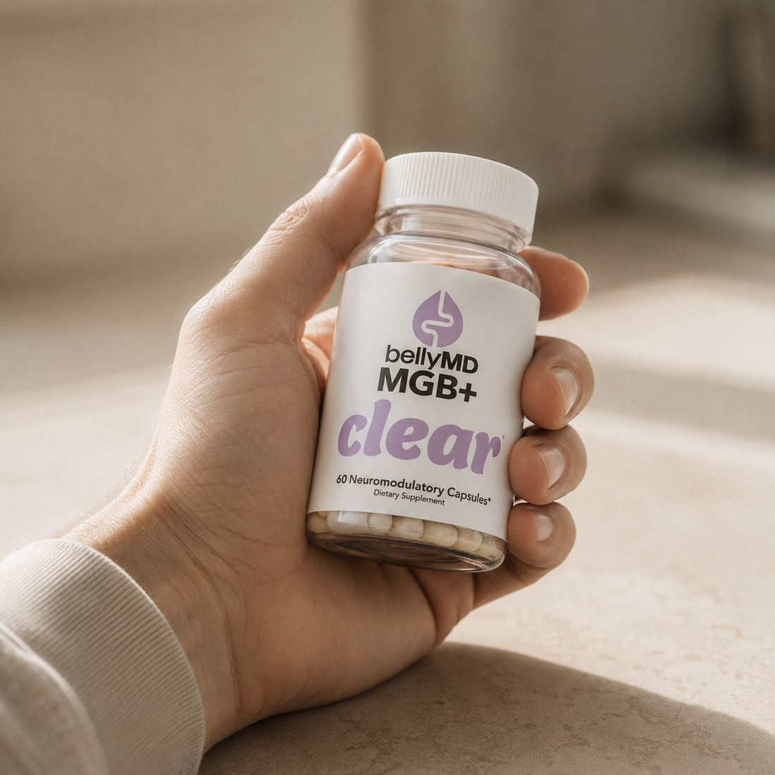 A hand holding a bottle of MGB+ Clear