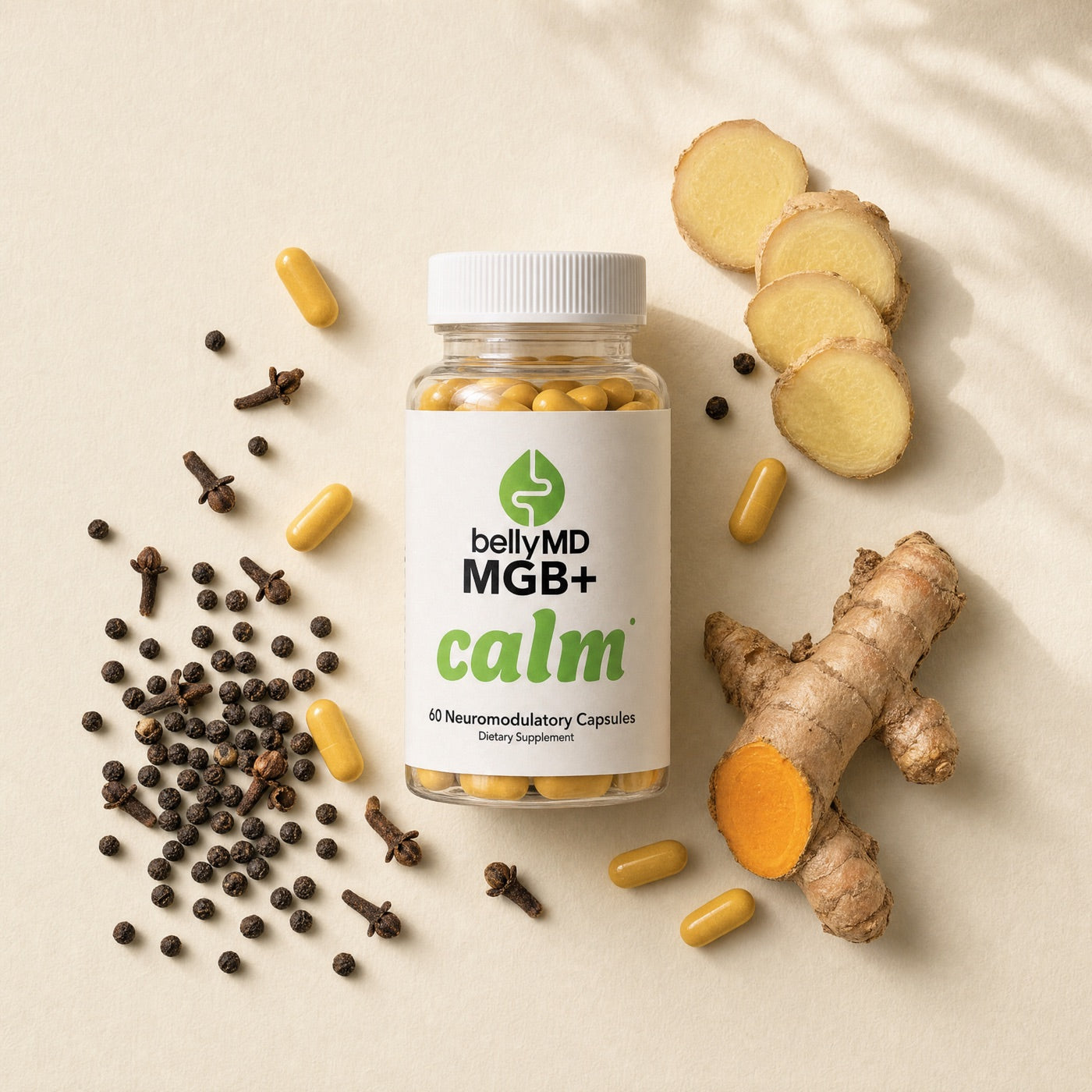 MGB+ Calm bottle on cream paper with black peppercorns, ginger root, turmeric, and yellow capsules arranged around it