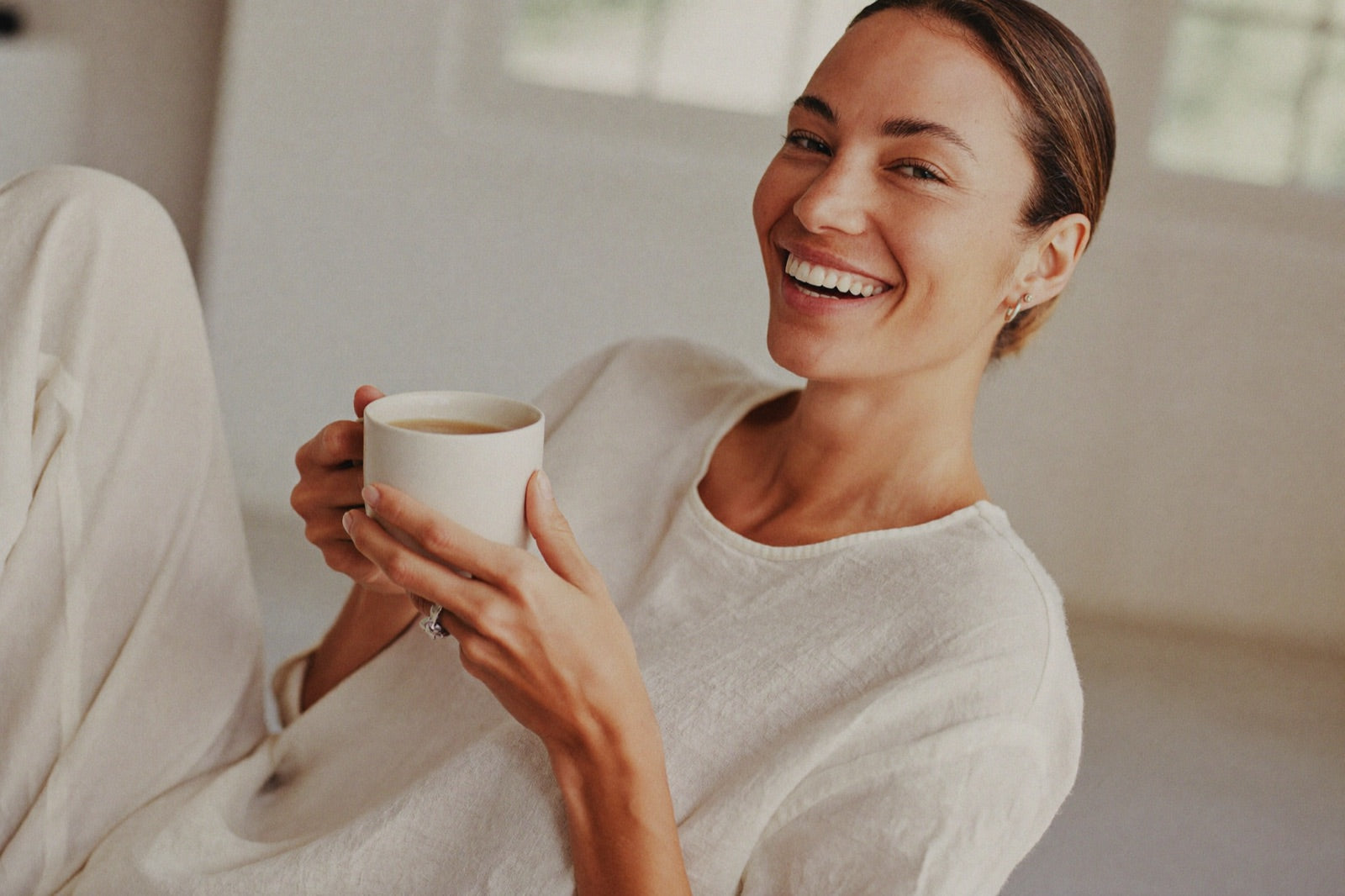 A woman in her 40s, relaxed and clear-headed, enjoying a calm morning with a cup of tea