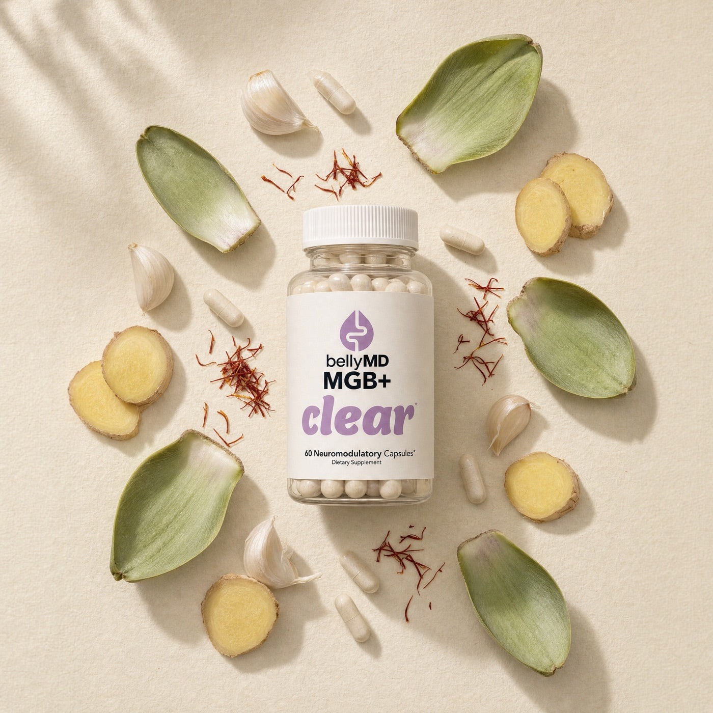 MGB+ Clear bottle surrounded by artichoke leaves, ginger, garlic, and saffron threads